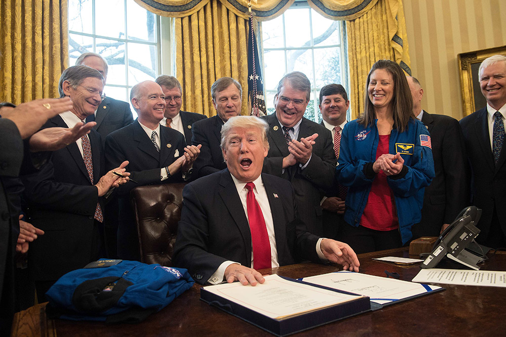 3月21日,在美国华盛顿白宫椭圆形办公室,美国总统特朗普(中)签署法案.