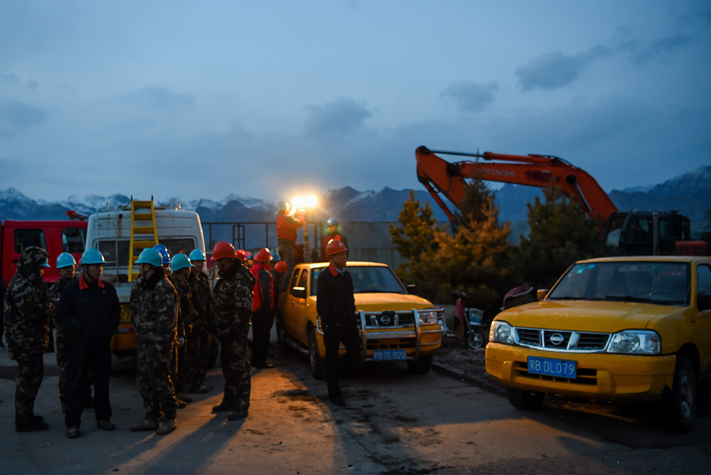 3月25日晚，救援人員在包頭市北隻圖村向陽小區爆炸事故現場附近待命。