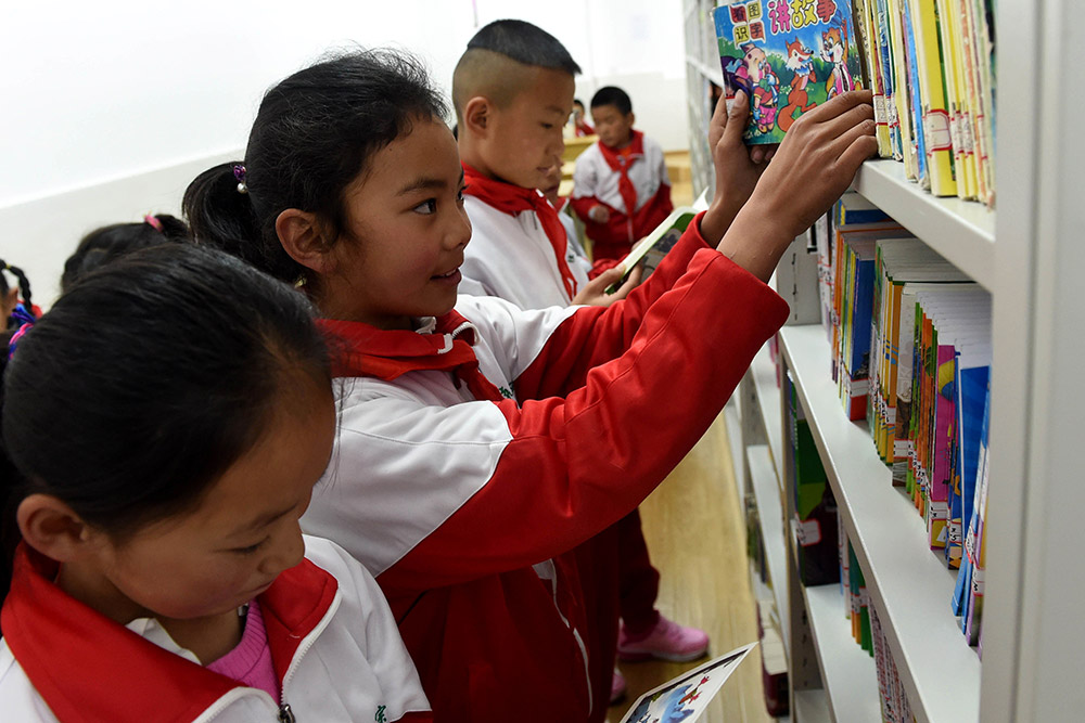 3月27日，獨克宗小學的9歲藏族女學生扎西央宗（中）在學校的圖書室裡選書。