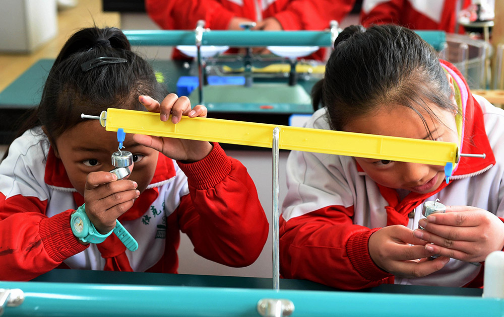 3月27日，獨克宗小學的兩名藏族女學生在科學實驗課上。