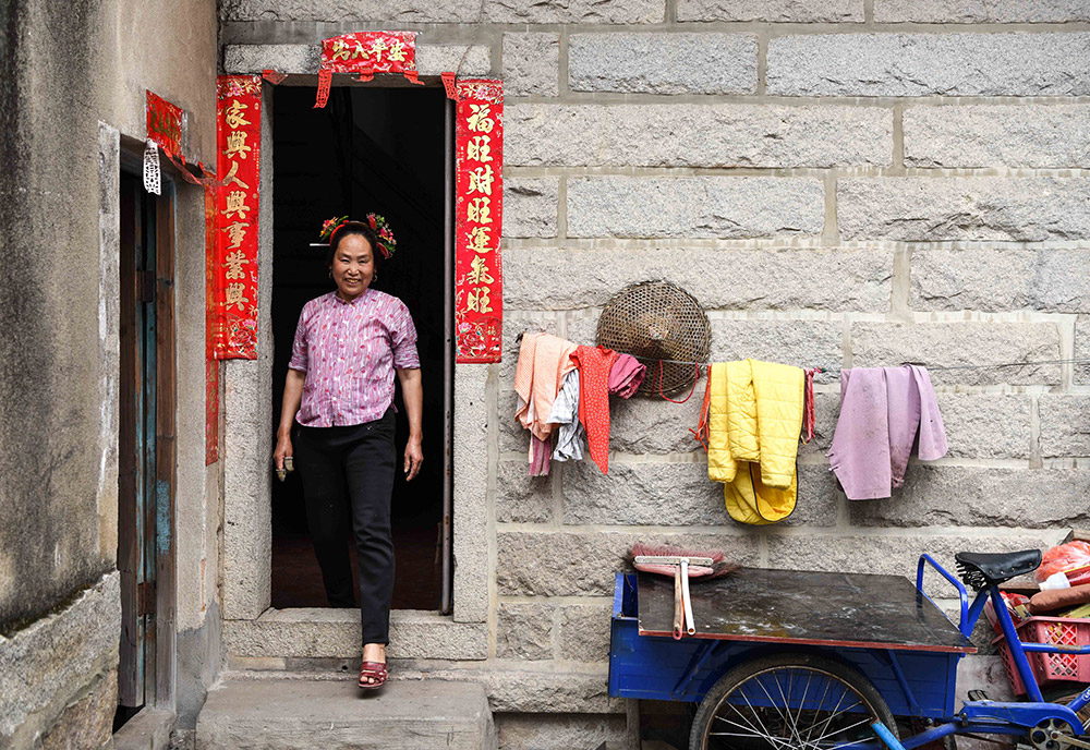 4月9日,在泉州蟳埔村,一名"蟳埔女"走出家门.