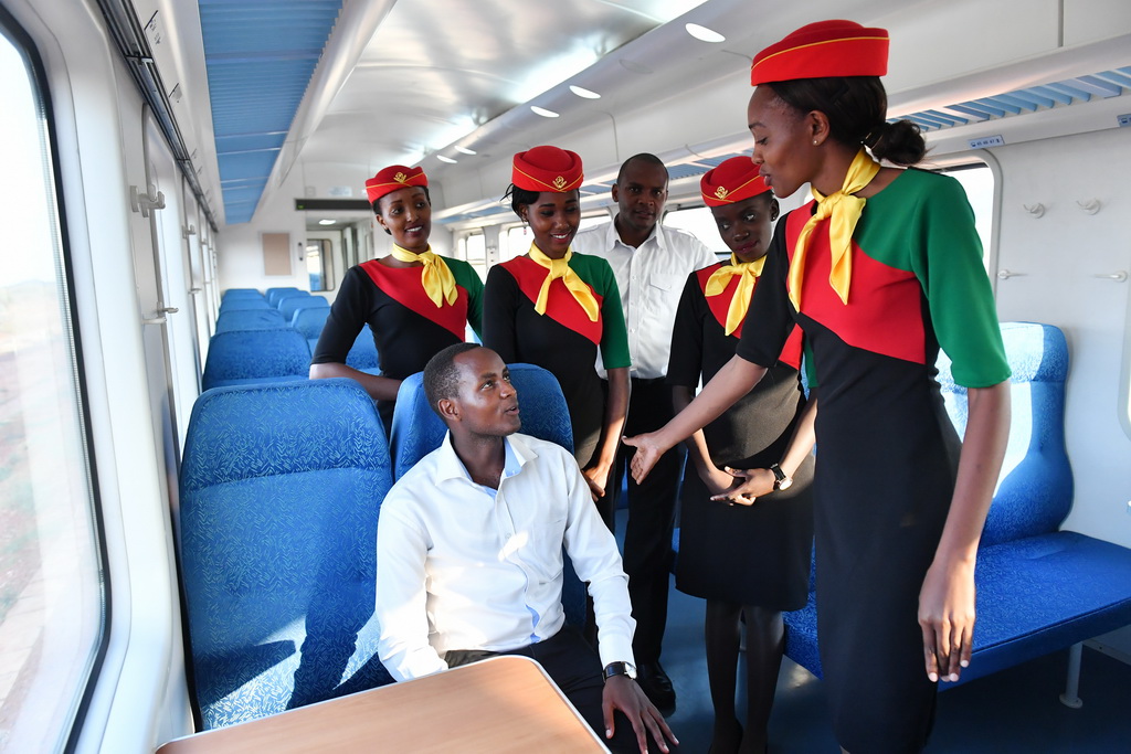 4月13日，在肯尼亞蒙內鐵路一列測試列車上，乘務員練習如何招待旅客。  新華社記者孫瑞博攝