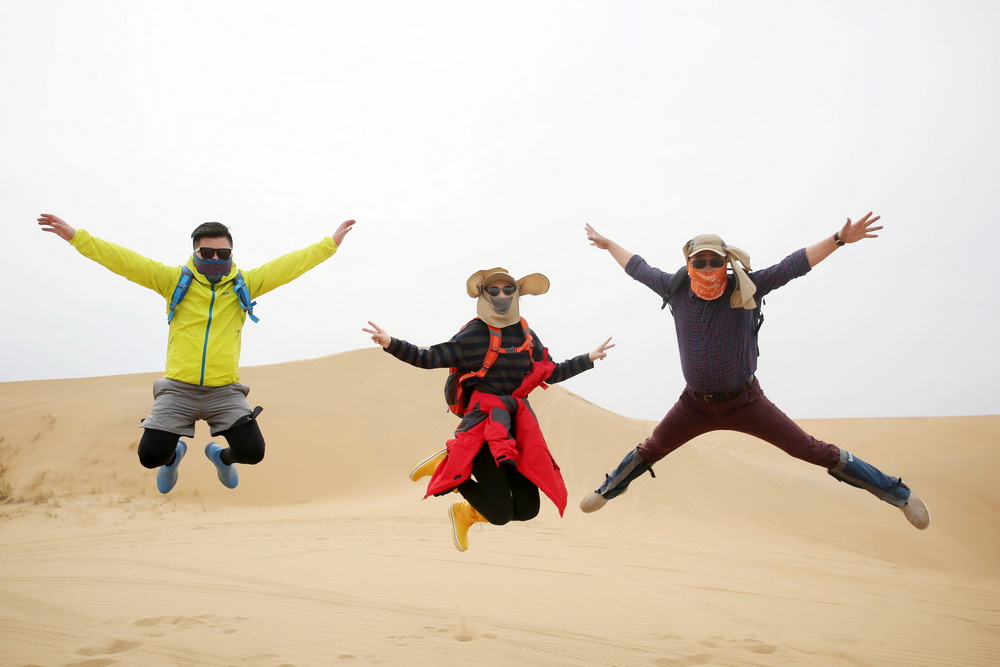 2017年4月15日，三位年輕人在內蒙古自治區達拉特旗庫布齊沙漠參加首屆“夢想之路”北京青聯沙漠徒步挑戰賽后開心地跳了起來。