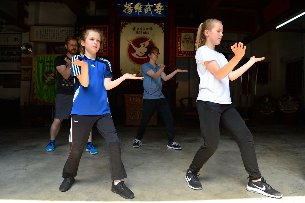 路易絲（前排左）跟父親、哥哥和姐姐一起在福建永春“翁公祠武術館”練習白鶴拳（4月20日攝）。 新華社記者魏培全攝