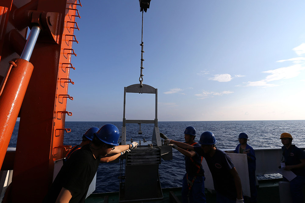 4月25日，科考队员用箱式取样器提取海底沉积物样品。