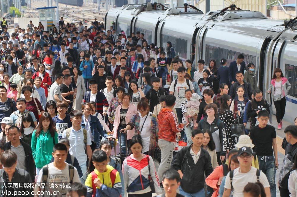 5月1日，旅客在山東煙台火車站下車准備出站。唐克/人民圖片