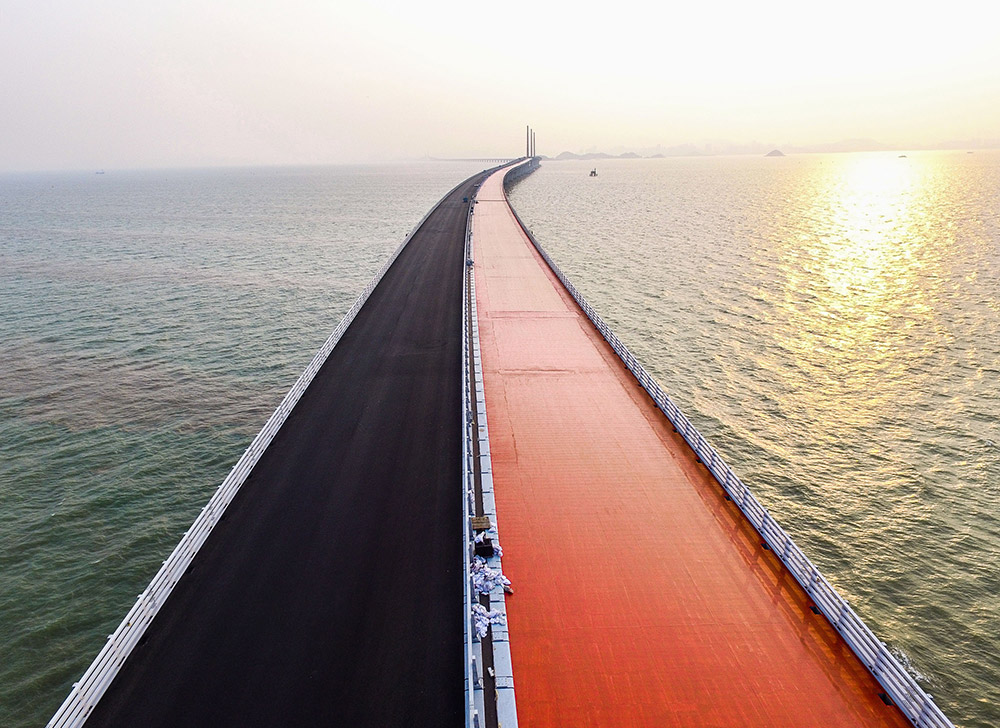 正在鋪設瀝青的港珠澳大橋江海航段橋面，紅色是鋪設瀝青前的保護涂層（4月29日攝）。
