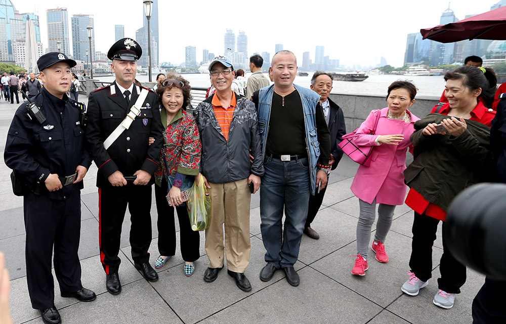 5月2日，中意警員在上海外灘與游客合影。