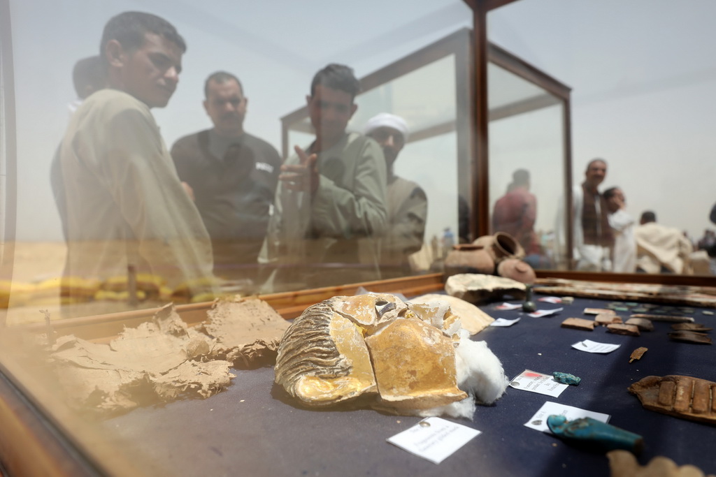 5月13日，在埃及中部明亚省，人们观看出土的文物。