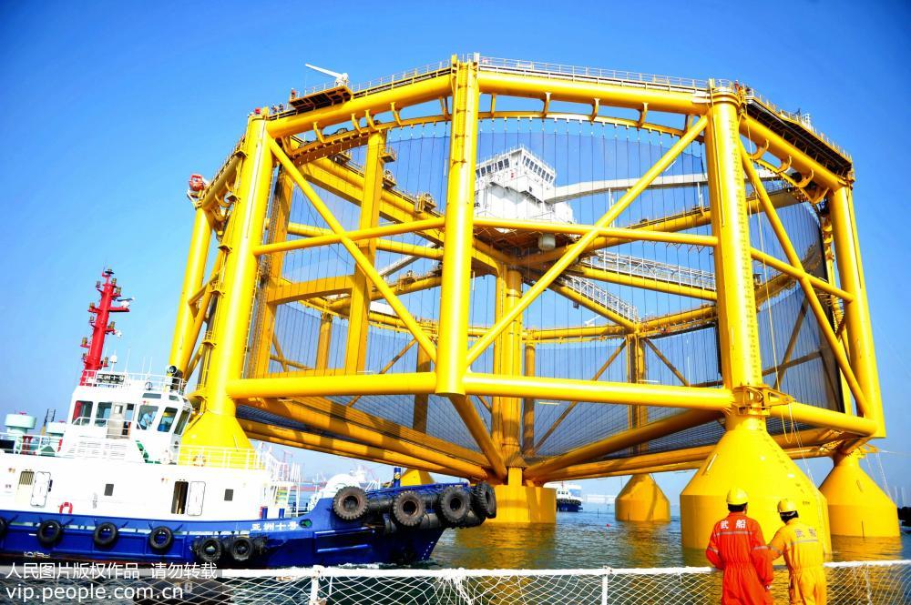 6月14日，山東青島武船重工碼頭，工作人員在關注啟運的海上漁場養魚裝備。俞方平/人民圖片