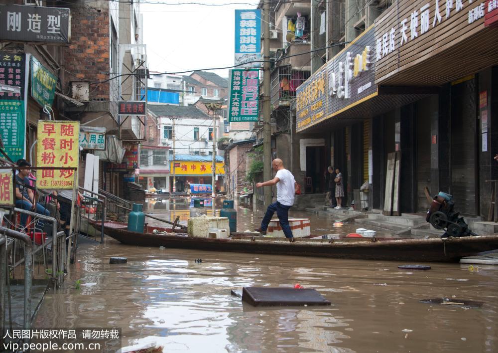 7月2日，湖南省新邵縣釀溪鎮居民走過用船搭起的臨時過道。