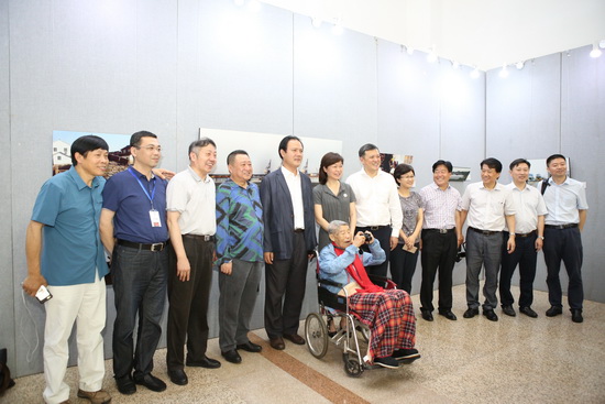 展览现场,袁毅平同嘉宾合影留念仍不忘举起手中相机创作。吴承欢摄-0764