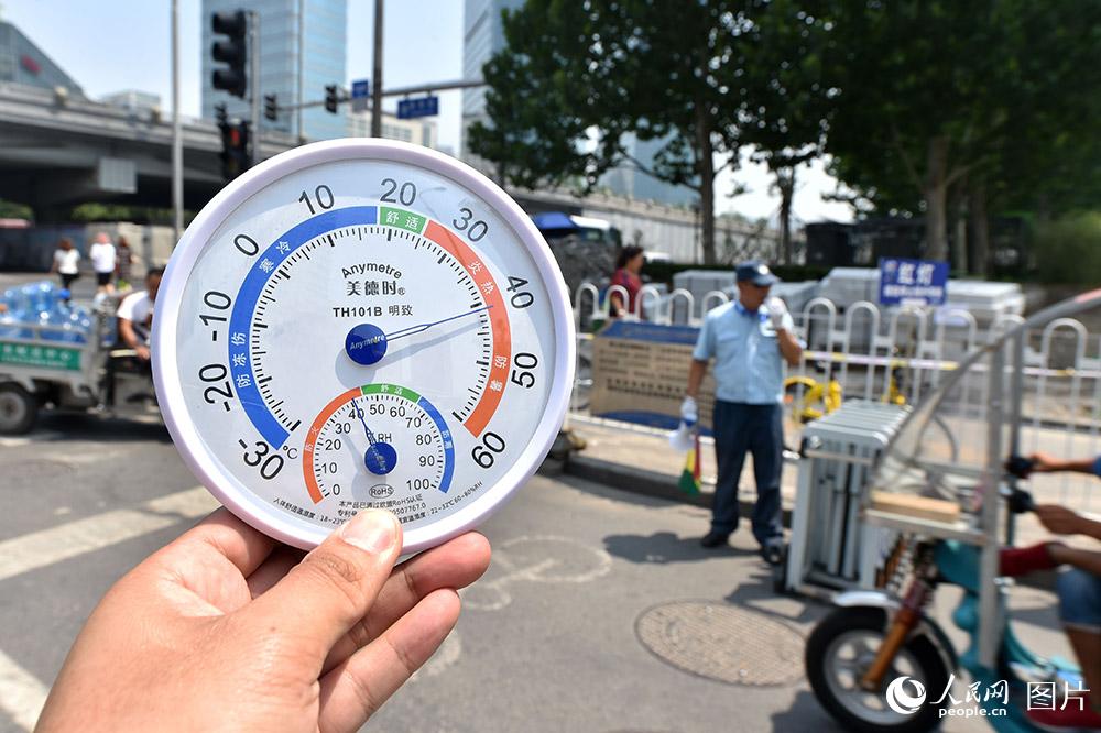 7月11日11點，北京CBD，交通協管員正在疏導交通。此時，烈日下的氣溫已超過40攝氏度，地表溫度接近50攝氏度。（人民網記者 翁奇羽 攝）