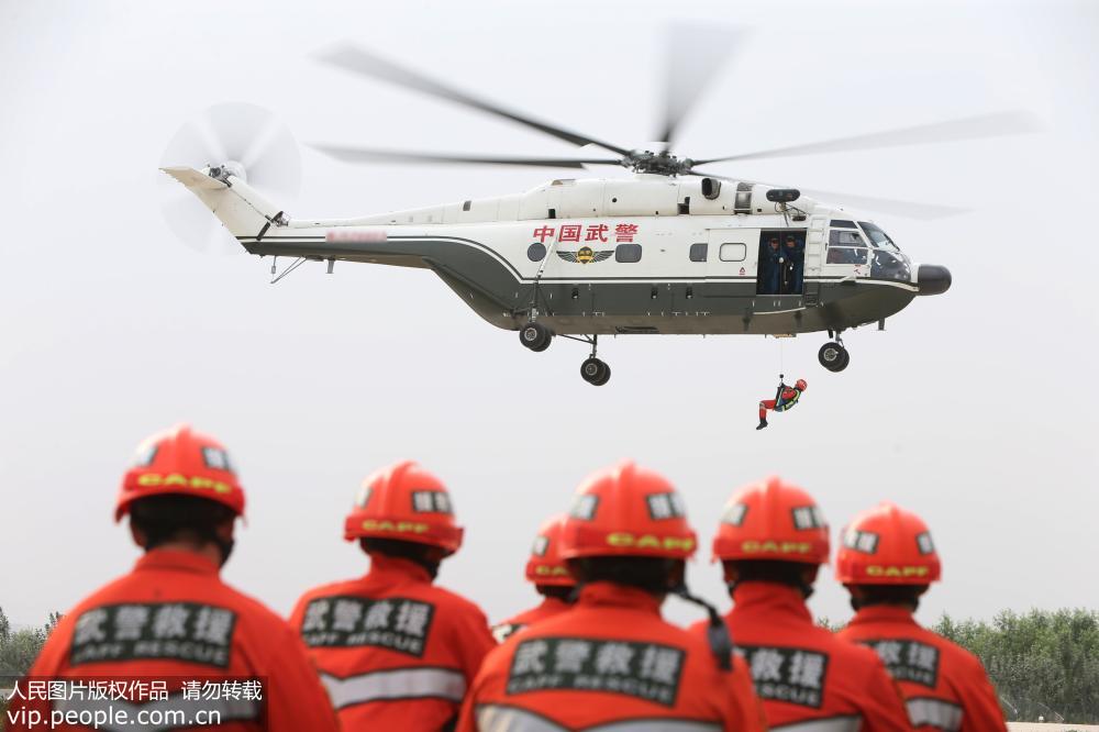 救援官兵搭乘武警直升機模擬救援訓練。