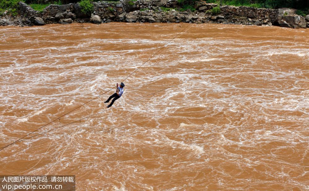 7月20日，貴州省威寧縣公安局海拉派出所的民警通過溜索橫跨牛欄江去為群眾辦理身份証。