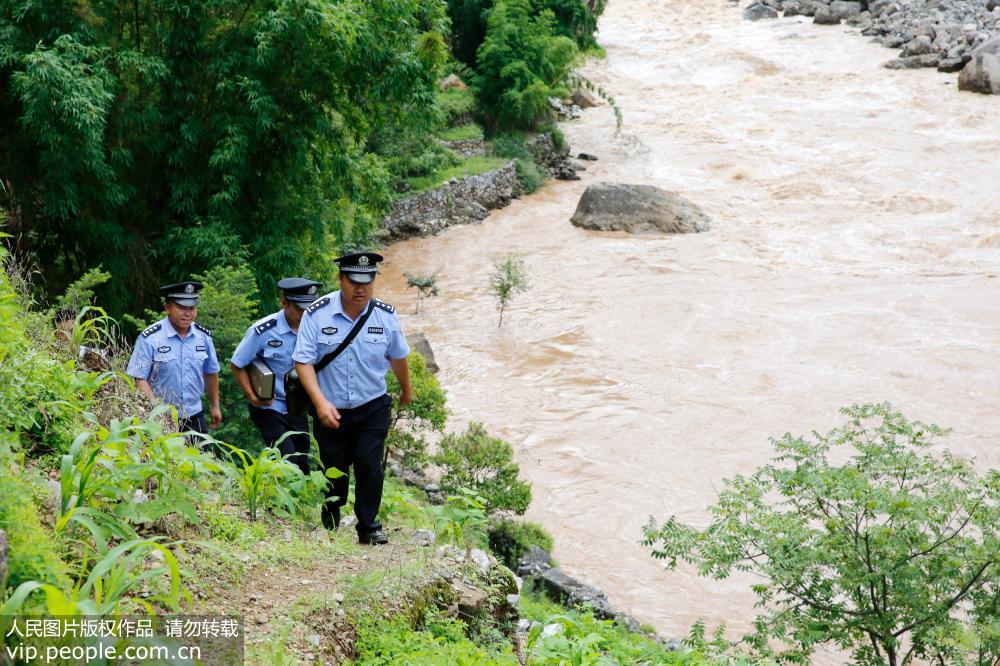 7月20日，貴州省威寧縣公安局海拉派出所的辦証民警行走在牛欄江畔。