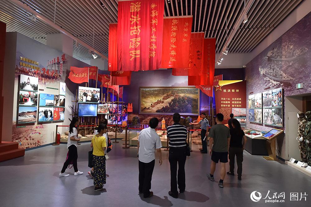 7月24日，在“銘記光輝歷史　開創強軍偉業——慶祝中國人民解放軍建軍90周年主題展覽”上，解說員在為參觀者講解。（人民網記者 翁奇羽 攝）