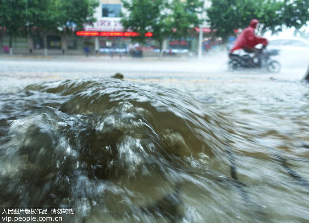 8月2日，山東省棗庄市山亭區府前路，雨水沖開窨井蓋流向路面。