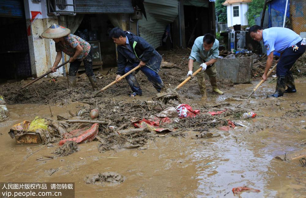 8月12日，在廣西柳州市融水苗族自治縣杆洞鄉杆洞街，鄉干部和群眾齊心協力清理洪水垃圾。