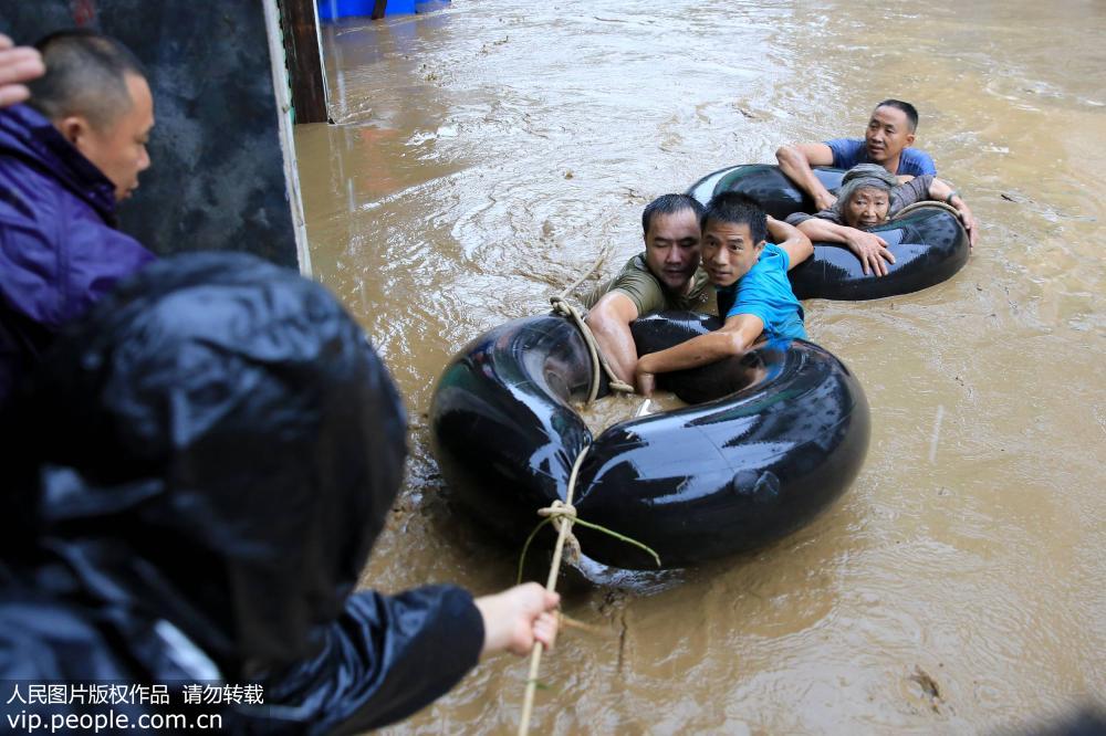 8月13日，在廣西柳州市融水苗族自治縣杆洞鄉杆洞街，搶險救援隊正在轉移80多歲的老人楊志（右二）。