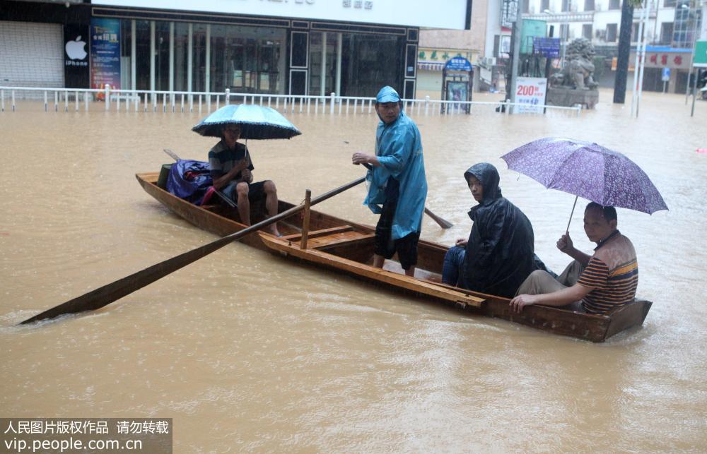8月14日，在廣西柳州市融水苗族自治縣被洪水浸泡的縣城街道，居民乘船出行。