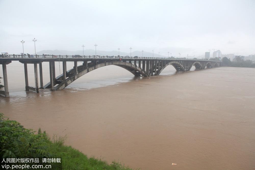 8月14日，在廣西柳州市融水苗族自治縣縣城境內，洪水從融水大橋下奔流而去。