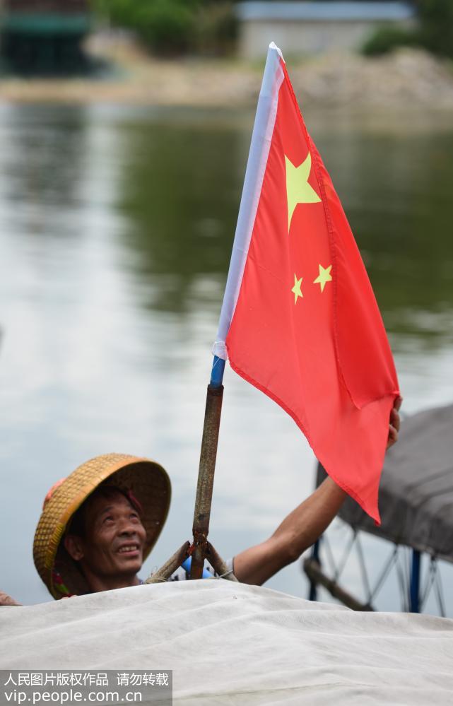 8月16日，海南省瓊海市潭門港，漁民懸挂國旗准備起航。