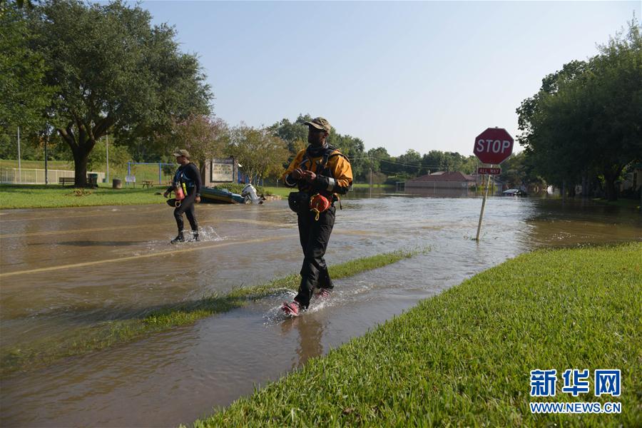 9月1日，在美國得克薩斯州休斯敦西部郊區，兩名搜救人員走在被洪水淹沒的街道上。