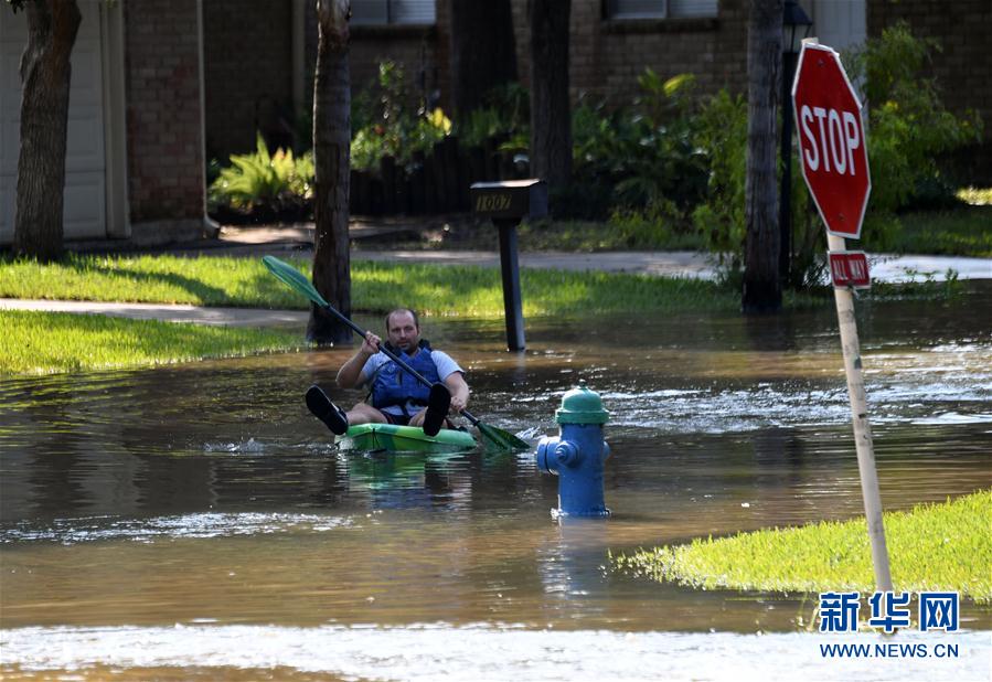 9月1日，在美國得克薩斯州休斯敦西部郊區，一名男子在被洪水淹沒的街道上劃船前行。