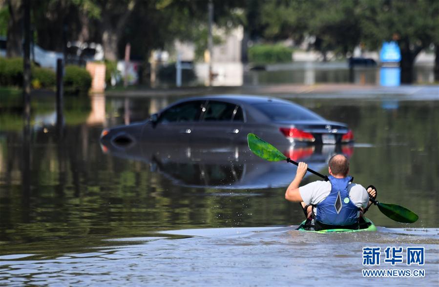 9月1日，在美國得克薩斯州休斯敦西部郊區，一名男子在被洪水淹沒的街道上劃船前行。