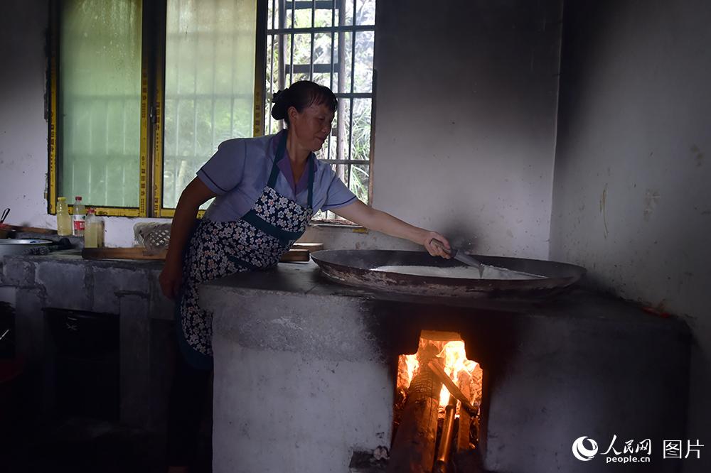9月9日，在匠心園豆腐坊，52歲村民費元芳正在為游客推豆花。費元芳告訴記者，在匠心園工作，一個月能有3000左右的收入。（人民網記者 翁奇羽 攝）