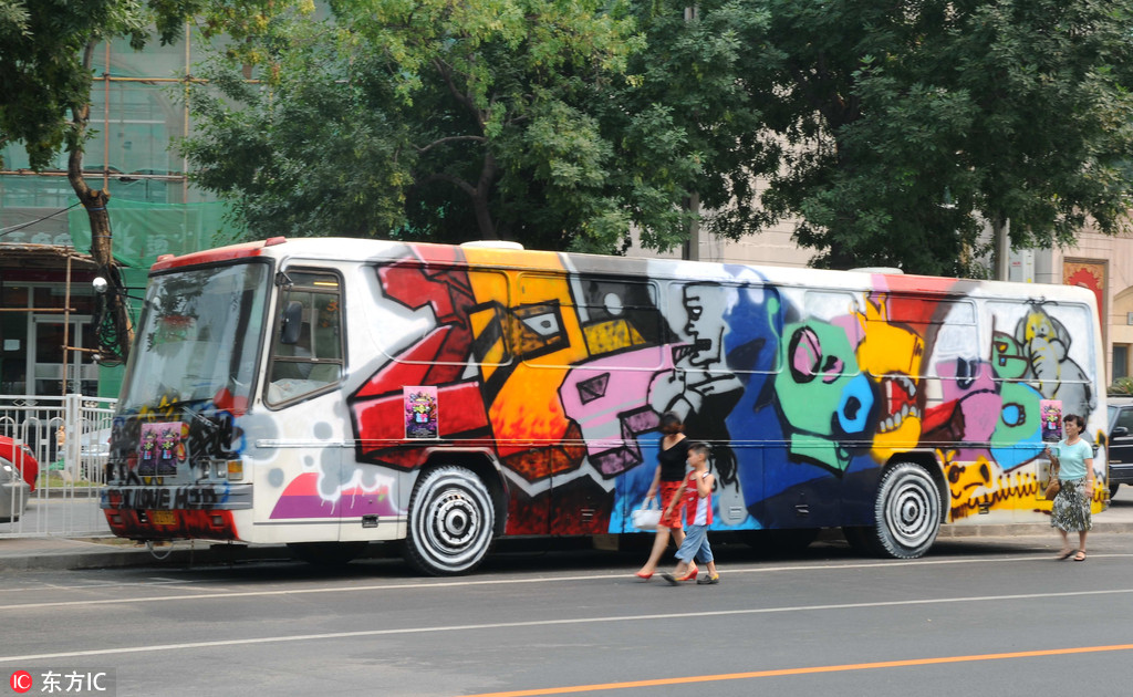 在北京朝陽區花家地附近路邊，一輛由美院學生“肆意”涂鴉的大巴格外顯眼，成了盛夏街頭一道獨特風景。該車是一商家為招聘員工而設立的，其目的是（車內）避暑和創意奪人。樊甲山/東方IC （2009年7月4日）
