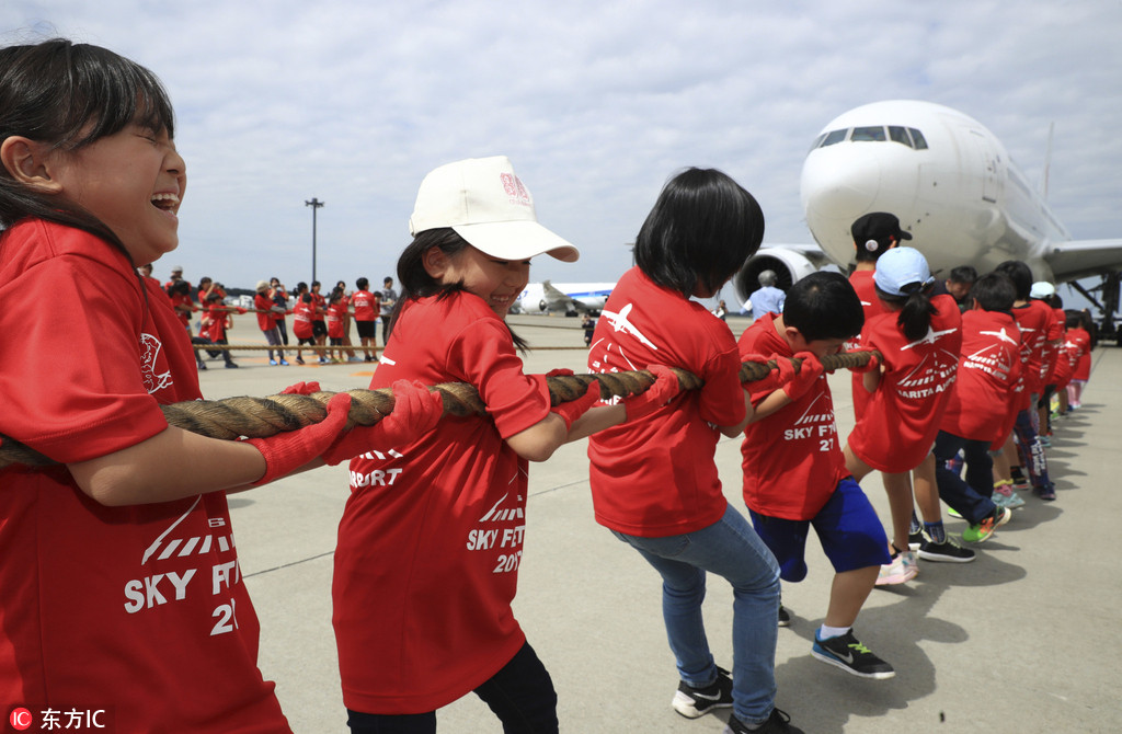 日本千叶县举办奇葩拔河赛 小学生与200吨大飞