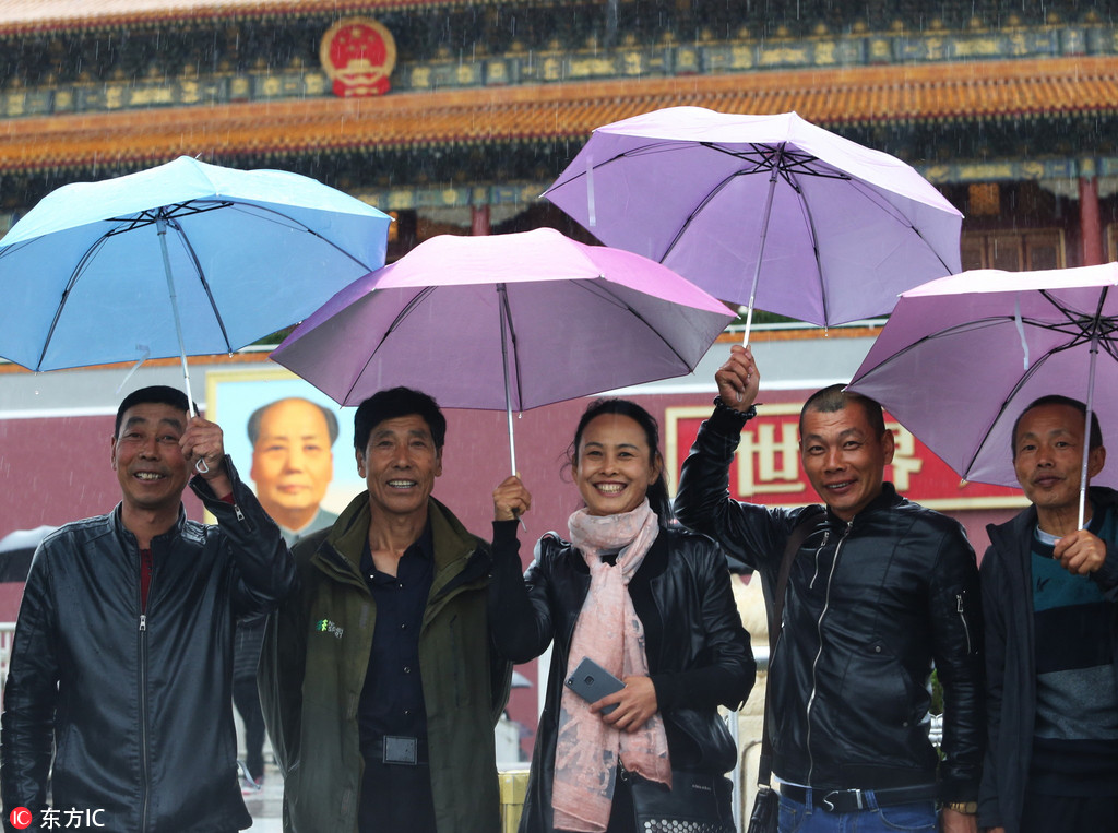 北京遭遇強降雨氣溫大“跳水” 游客冒雨游覽天安門廣場
