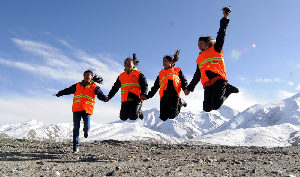10月23日，在青藏鐵路格拉段玉珠峰站，信號女子工班的4名女職工在海拔4100多米的昆侖雪山下一起跳躍。