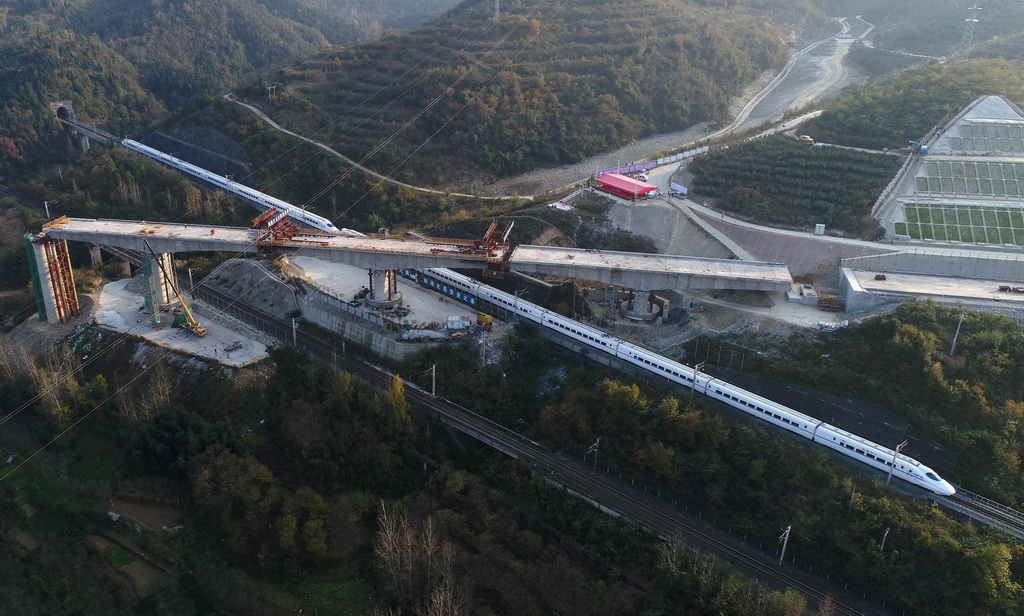 11月7日，一列動車通過轉體對接完成后的漢十高鐵三墩轉體橋施工現場。  新華社發（陶德斌 攝）