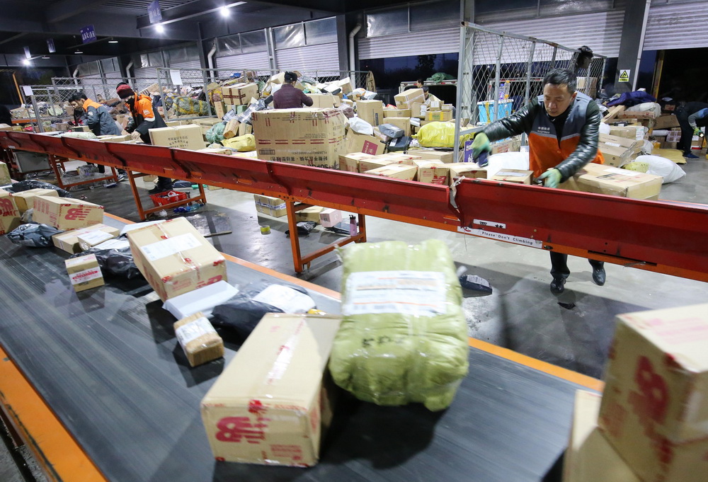 11月12日清晨，在山东省潍坊市一家快递公司分拣中心，工作人员在分拣货件。 新华社发（张驰 摄）