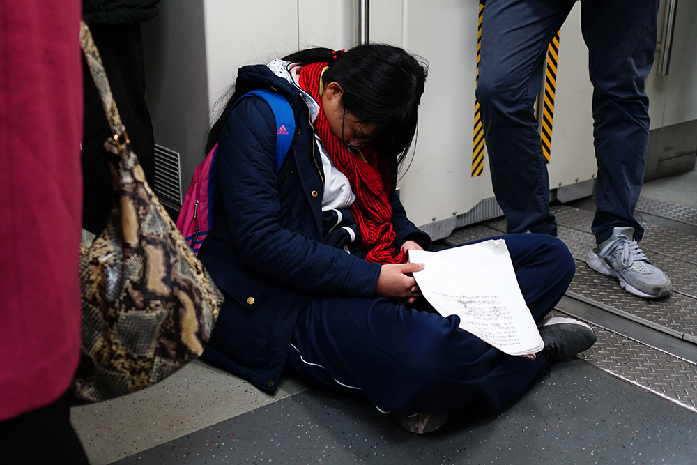 北京:地铁早高峰中学生手握试卷疲惫睡著 乘客