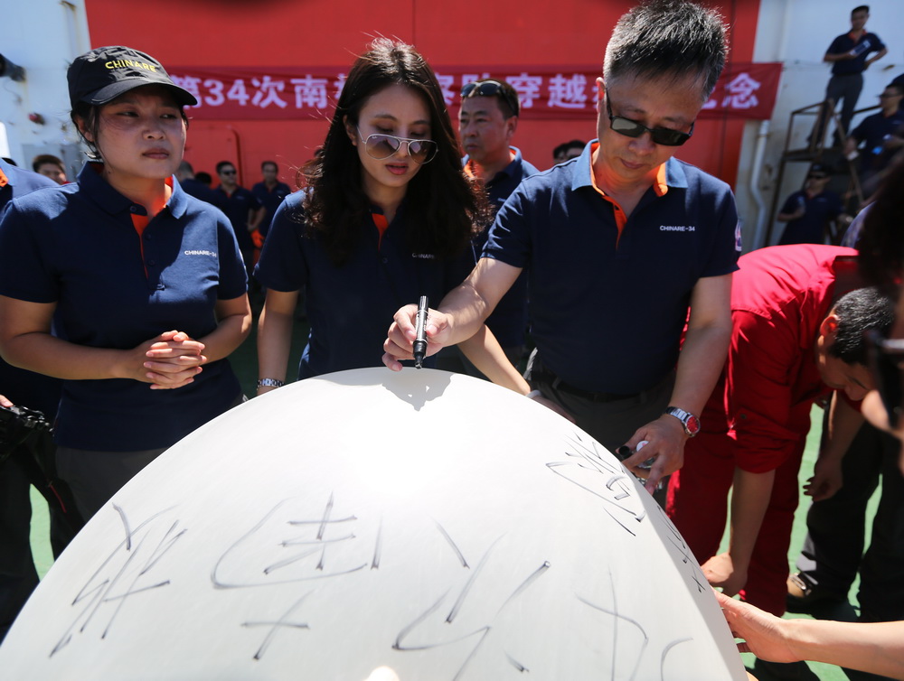 11月15日，在“穿越赤道紀念儀式”上，中國第34次南極科考隊隊員在即將放飛的氣球上寫下美好的祝願。