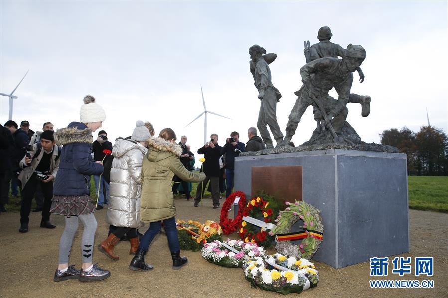11月15日，在比利时西佛兰德省波珀灵厄市布思本村，当地儿童为一战华工纪念雕像献花。