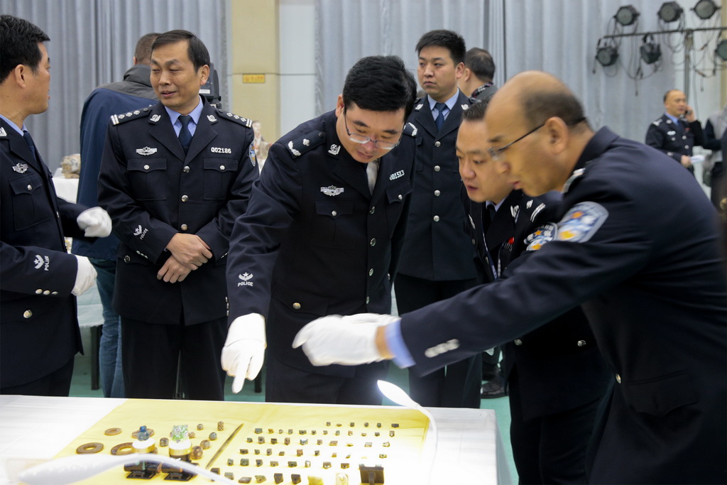 11月17日，民警在發布會現場研判破案追回的文物。 新華社發（陳路坤攝）