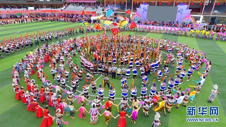 11月18日，在广西融水举办的苗族芦笙斗马节开幕式上，当地群众与游客参加“打同年”仪式。