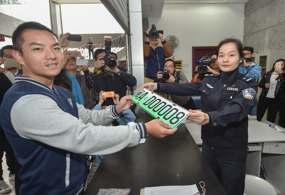 11月20日，在福州市交警支隊車輛管理所，民警向市民林先生發放當地第一張新能源汽車專用號牌。