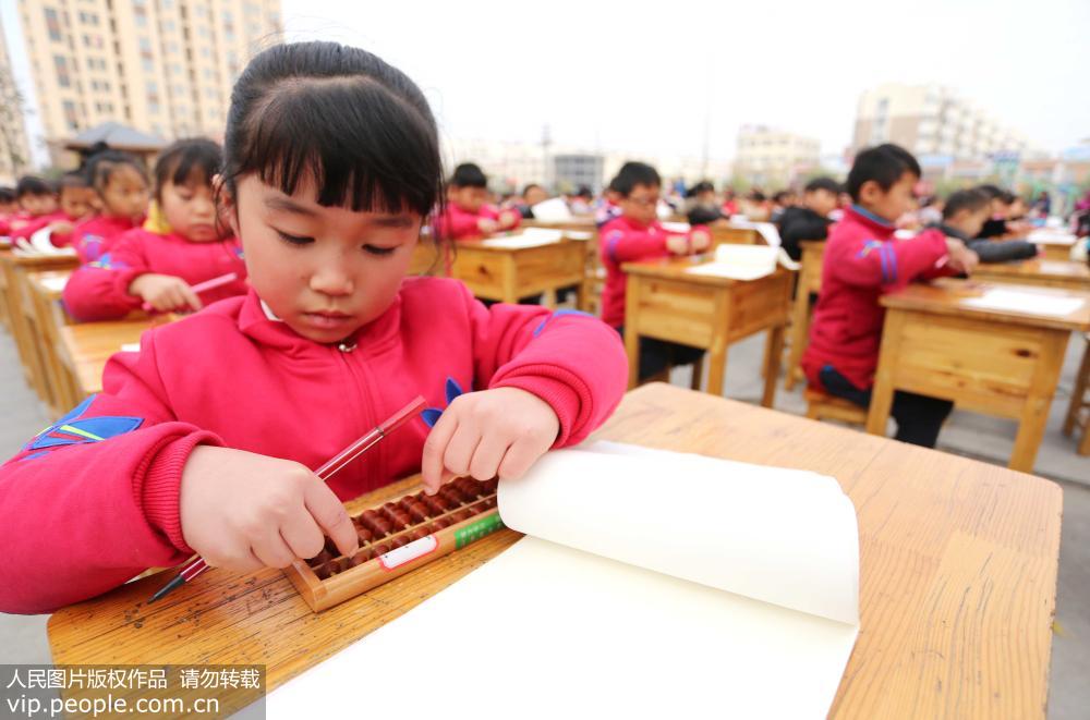 11月21日，江蘇省東海縣實驗小學的一年級學生在操場上進行珠心算演示。