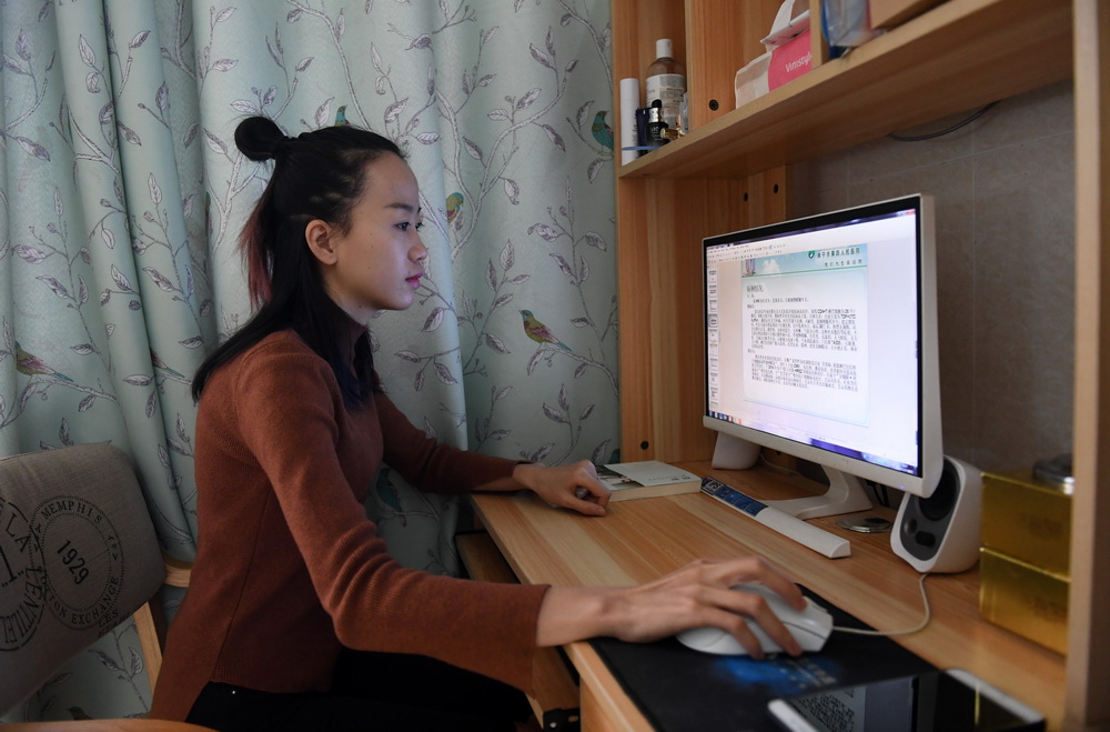 在廣西南寧市燕子嶺，郭應玲在出租屋裡查閱有關醫療護理資料（11月29日攝）。