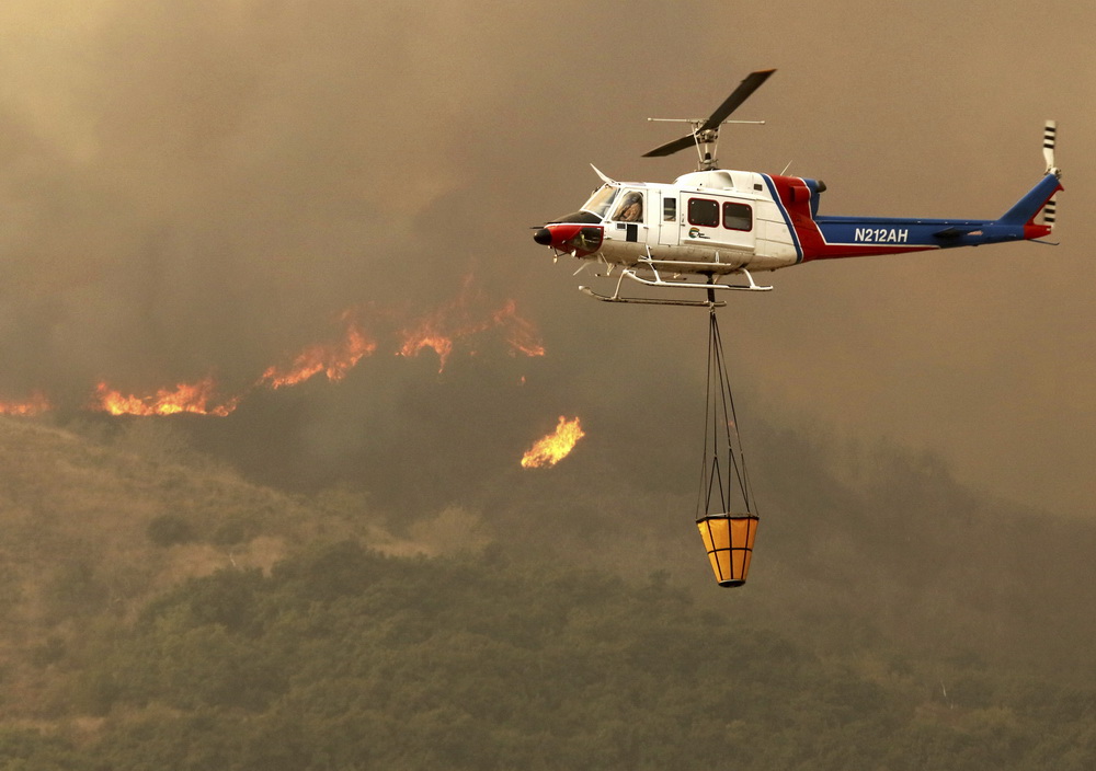 12月5日，在美國加利福尼亞州南部文圖拉縣，一架直升機參與滅火。新華社/美聯
