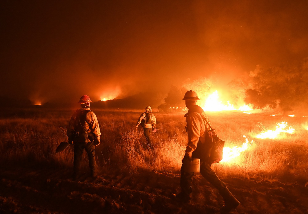 12月9日，在美国加利福尼亚州奥哈伊，消防员在火灾现场工作。新华社/法新