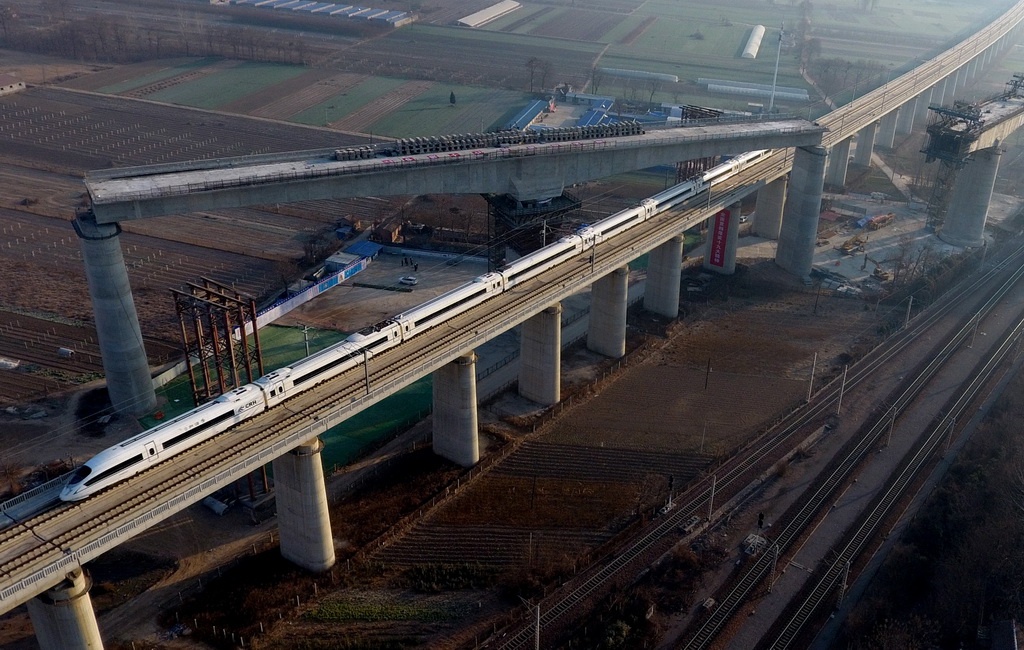 12月19日，一列高铁从转体成功后的商合杭高铁跨郑徐高铁T构梁下驶过。商合杭高铁线路全长794.55公里，设计时速350公里。新华社发（李嘉南 摄）
