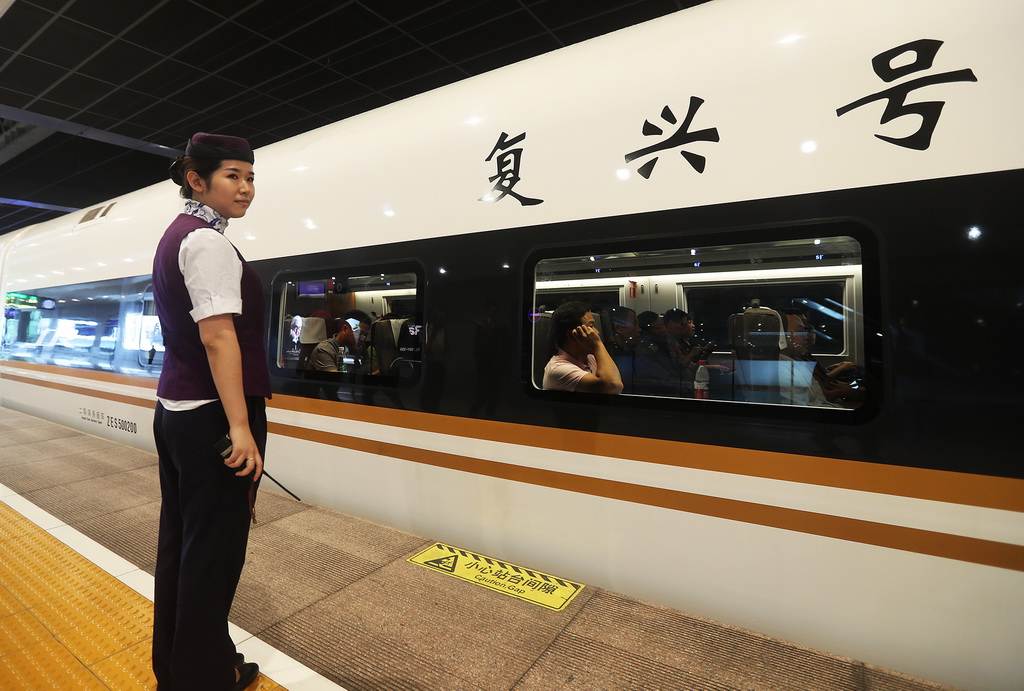 上海虹桥站站台值班员薛蔚正在观察G2次“复兴号”列车旅客上车情况（9月21日摄）。“复兴号”以350公里时速的正式运营，标志着我国成为世界高铁商业运营速度最高的国家。新华社记者 陈飞 摄