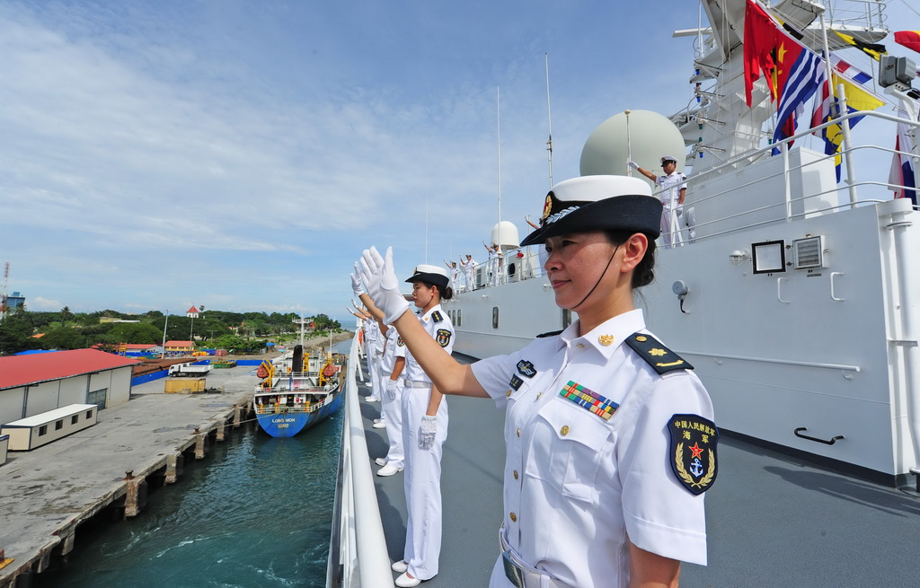 12月21日，中国海军和平方舟医院船离开东帝汶帝力港时，医护人员向前来送行的人群挥手告别。新华社发（江山摄）